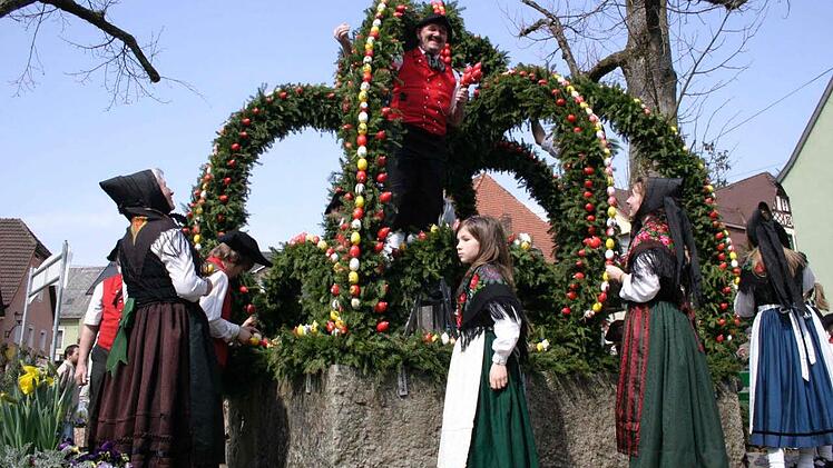 Die Trachtengruppe "D Wiesenttaler" schmücken den Brunnen in voller Montur.