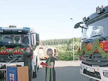 Gabriele T&ouml;pfer und Peter Tischer segnen die Feuerwehrfahrzeuge, die in D&ouml;rfles-Esbach und R&ouml;dental eingesetzt sind.