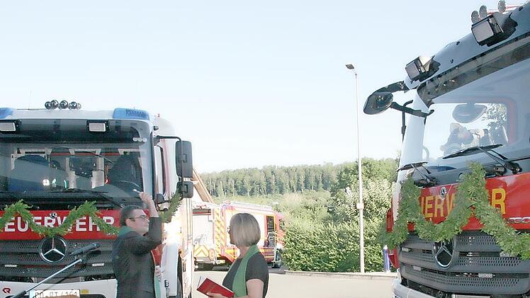 Gabriele T&ouml;pfer und Peter Tischer segnen die Feuerwehrfahrzeuge, die in D&ouml;rfles-Esbach und R&ouml;dental eingesetzt sind.