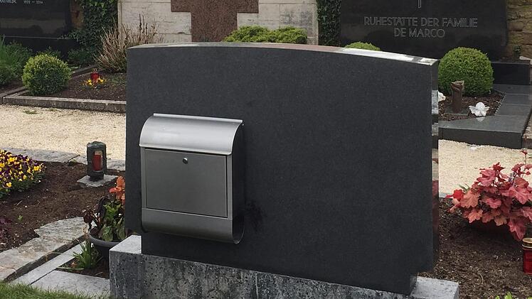 Auf dem Friedhof von Gerolzhofen hat ein Hobbybastler einen Briefkasten an die R&uuml;ckseite eines Grabsteins geschraubt, um darin Gartenwerkzeuge aufzubewahren. Die Idee findet viel Anklang. Foto: Klaus Vogt