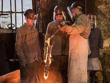 Mitarbeiter der Glockengießerei Rincker in Sinn (Hessen) messen hinter dem Tiegelofen die Temperatur der flüssigen Bronze für den Guss einer Glocke. Wer den Beruf des Glockengießers lernen möchte, sucht in Franken derzeit vergeblich nach einem Ausbildungsplatz. Foto: F. Rumpenhorst, dpa