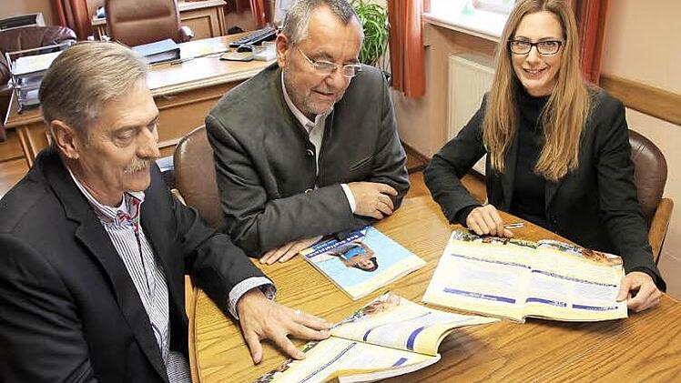 Peter Bäumel (von links), Jürgen Kohmann und Anne Maria Schneider blättern im neuen Gästeverzeichnis der Stadt, das jetzt erschienen ist. Foto: Tobias Kindermann