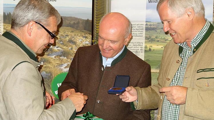Landrat Thomas Habermann (Mitte) wurde die "Medaille Naturerbe Bayern in Gold" von Prof. Dr. Jürgen Vocke, Präsident des Bayerischen Jagdverbandes (rechts), und Vizepräsident Enno Piening überreicht. Foto: Marion Eckert