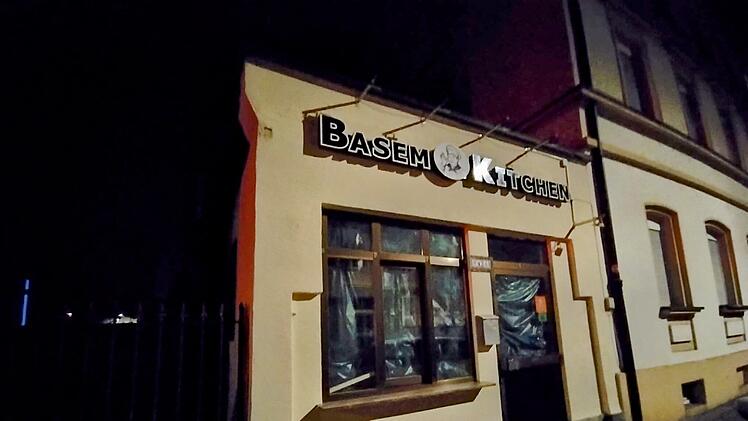 Das Bild zeigt ein Gebäude mit dem neuen Schriftzug "BASEM KITCHEN", ehemals "Pizzeria Bella Napoli" in Bamberg. Die Fenster sind teils verhüllt. Es ist Nacht.