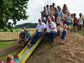 Die Kinder freuen sich über die neuen Spielgeräte. Auf der Rutsche sitzt Bürgermeister Gerald Brehm, daneben Stadtrat Josef Beßler.  Foto: L.. Händel