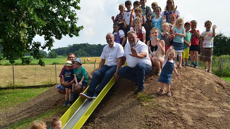 Die Kinder freuen sich über die neuen Spielgeräte. Auf der Rutsche sitzt Bürgermeister Gerald Brehm, daneben Stadtrat Josef Beßler.  Foto: L.. Händel