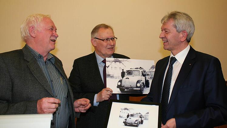 Kreisheimatpfleger Wolfgang Rössler (Mitte) und Dieter Hagen (links) überraschten Landrat Hans Kalb mit einem Foto von der elterlichen Kohlenhandlung. Der Vater des Landrats sitzt am Steuer des Magirus. Foto: Evi Seeger