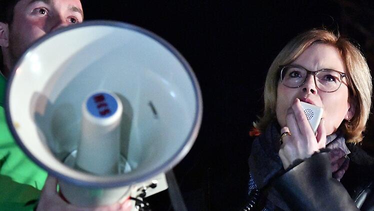 Julia Kl&ouml;ckner (CDU), Bundeslandwirtschaftsministerin, spricht mit einem Magafon zu demonstrierenden Bauern. Sie hatte an einem Gespr&auml;ch im Rathaus &uuml;ber die "Zukunft Landwirtschaft und l&auml;ndlicher Raum" teilgenommen und zuvor die Lager des Bio-Gro&szlig;h&auml;ndlers dennree besichtigt. Foto: Martin Schutt/dpa