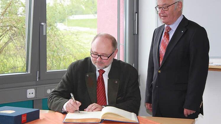 Der Bürgermeister und der Landrat (stehend) trugen sich ins goldene Buch der Stadt ein.