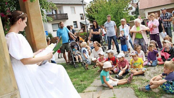 Am Dorfbrunnen lauschten die Kinder der Kurzfassung des Märchens vom Froschkönig.