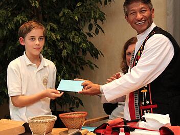Ryan übergibt eine Spende vom Schulfest an Pater Samuel.  Foto: Richard Sänger