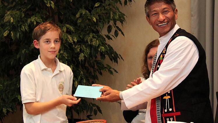 Ryan übergibt eine Spende vom Schulfest an Pater Samuel.  Foto: Richard Sänger