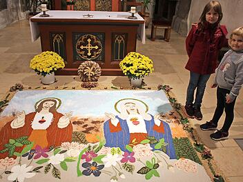 "Herz Jesu und Herz Mariens" ist der Titel des Andachtbildes, das bis Allerheiligen in der Kirche zu besichtigen ist. Die siebenjährige Eva und die fünfjährige Lena wurden schon in die Tradition eingebunden  Fotos: Seeger