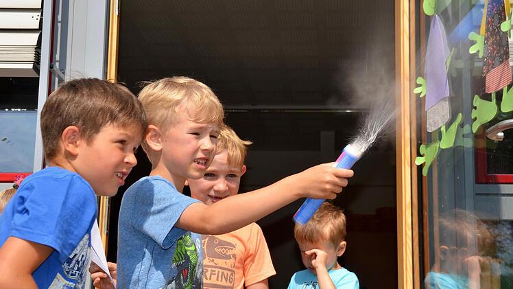 Sprudelbomben zu bauen, steht bei den Forschern in Premich ganz oben auf der Liste. Hier zündet Hannes eine, was Fabrice (links) und Lennard aufmerksam verfolgen. Foto: Kathrin Kupka-Hahn
