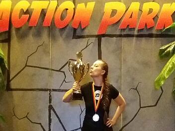 Jennifer Düngfelder freut sich über den Sieg beim Lasertag-Turnier in Nürnberg und posiert mit Pokal.