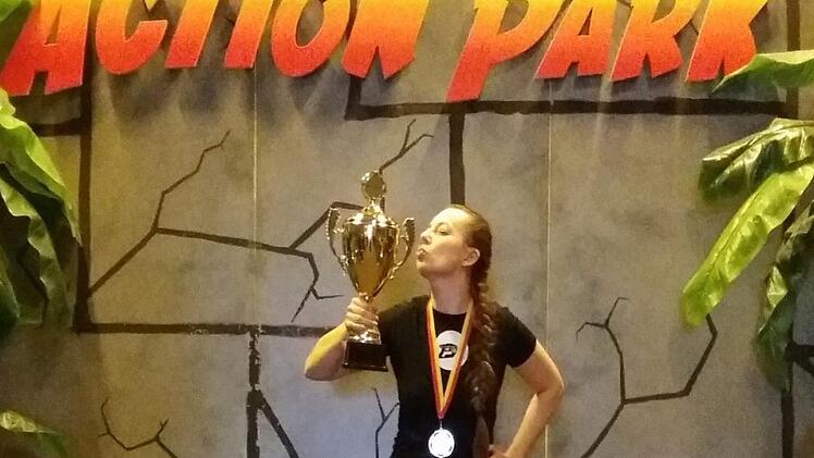 Jennifer Düngfelder freut sich über den Sieg beim Lasertag-Turnier in Nürnberg und posiert mit Pokal.