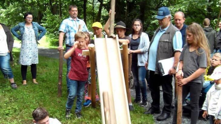 Über eine Rutsche wurde das "Blöchla" von den Kindern zu Wasser gelassen. Michael Kestel (mit Mütze) passt auf, Felix Neder (kniend) bringt die Blöchla in die richtige Position. Foto: Susanne Deuerling