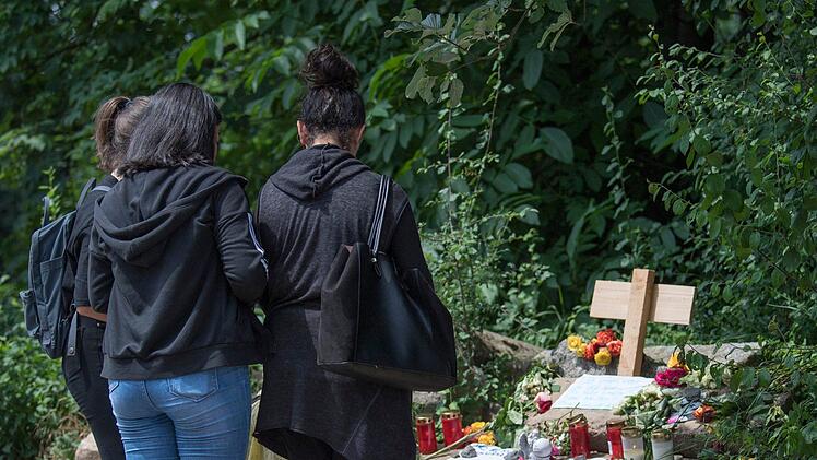 Junge Frauen legen an einer provisorischen Gedenkstätte für die getötete Susanna F. Blumen nieder und entzünden Kerzen. Die 14-jährige wurde Opfer eines Sexualdeliktes. Der mutmaßliche Täter hatte sich in sein Heimatland Irak abgesetzt, wo er mittlerweile festgenommen wurde. Foto: Boris Roessler/dpa