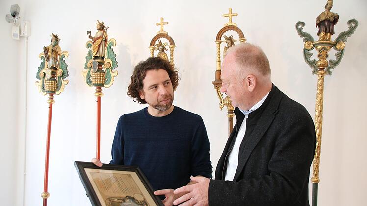 Museumsleiter Nicolas Zenzen (links) bereitet derzeit die Sonderausstellung "Handwerk hat goldenen Boden - Der Glanz der Münnerstädter Zünfte"vor.  Mit Bürgermeister Helmut Blank unterhält er sich hier über einen Gesellenbrief. Thomas Malz