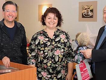 Rupert Meyer überreicht Tanja Münch das Weihnachtsgeschenk für das tüchtige Team des Cafés, links Bürgermeister Karsten Fischkal Foto: Johanna Blum