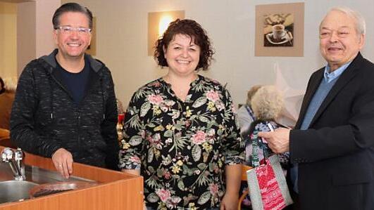Rupert Meyer überreicht Tanja Münch das Weihnachtsgeschenk für das tüchtige Team des Cafés, links Bürgermeister Karsten Fischkal Foto: Johanna Blum