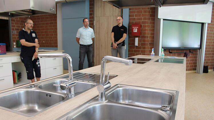 Im bereits sanierten Teil der Schule befindet sich die neue, komfortable  Lehrküche. Konrektor Marco Genzler (von links), Rektor Michael Heyne und Ingenieur Bastian Wagner erklären die Vorteile. Foto: Julia Raab