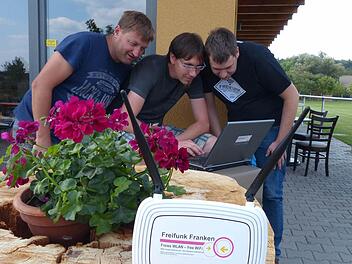 Die Technik läuft: Robert Streng und Alexander Gutzeit (beide Freifunk Franken) richteten den Hotspot in Fatschenbrunn am Sportheim ein. Der SV-Vorsitzende Frank Fösel (von rechts) schaut zu.  Foto: Klaus Schmitt