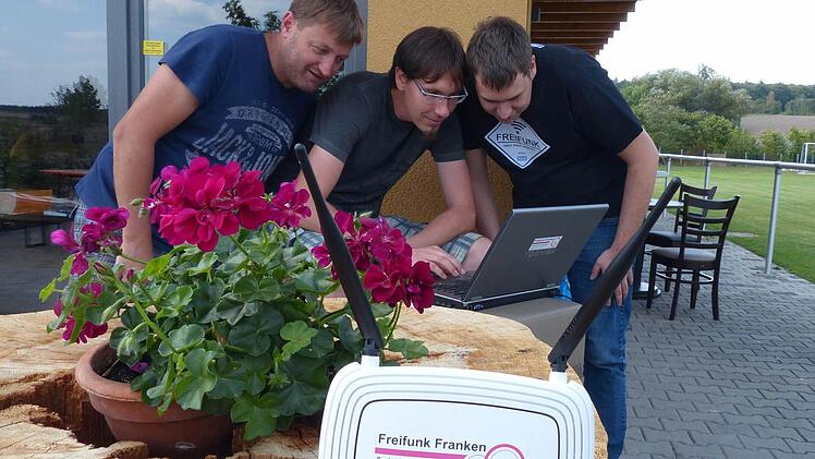 Die Technik läuft: Robert Streng und Alexander Gutzeit (beide Freifunk Franken) richteten den Hotspot in Fatschenbrunn am Sportheim ein. Der SV-Vorsitzende Frank Fösel (von rechts) schaut zu.  Foto: Klaus Schmitt