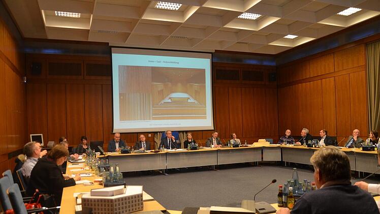 Stadtratsdebatte im holzvertäfelten (alten) Sitzungssaal über das neue Rathaus. Auch die Gestaltung des künftigen Ratssaals (siehe Fotobeispiel auf der Leinwand) war Thema. Beschlossen wurden jetzt lediglich die Materialien. Über die Ausgestaltung wird noch zu reden sein.  Foto: Bernhard Panzer