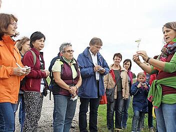Heidi Rippel (rechts) zeigt an einer Pflanze, welche Teile für die Wildkräuterküche verwendet werden können.Foto: Waltraud Enkert
