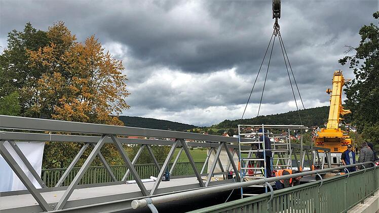 Bereits Ende September wurde die neue Fußgänger- und Radlerbrücke über die Saale als Fertigbauteil mit Hilfe eines Schwerlastkrans eingehoben. Foto: Lena Pfister