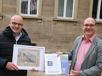Münnerstadts Bürgermeister Michael Kastl (links) und der Bürgermeister von Zwönitz, Wolfgang Triebert, zeigen, was sie bisher über das Klassenfoto aus Wermerichshausen, geschossen von einem Zwönitzer Fotografen, herausgefunden haben. Foto: Thomas Malz