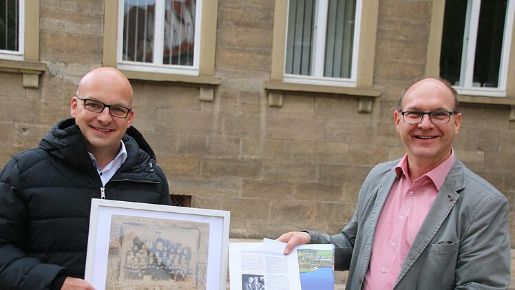 Münnerstadts Bürgermeister Michael Kastl (links) und der Bürgermeister von Zwönitz, Wolfgang Triebert, zeigen, was sie bisher über das Klassenfoto aus Wermerichshausen, geschossen von einem Zwönitzer Fotografen, herausgefunden haben. Foto: Thomas Malz