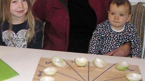 Mit Spannung erwartet Kurt Markert das Ergebnis seines Zwiebelorakels am Neujahrsabend. Gesellschaft leisten im seine Enkelinnen Marie (links) und Lina Zenk (rechts).