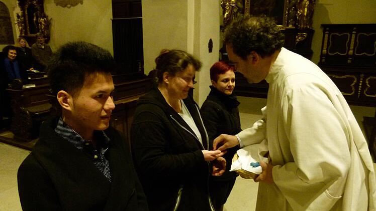 Jeanette, Madeleine und Amir bekommen als Symbol der Entschiedenheit und Hoffnung ein Kreuz überreicht. Foto: Krüger-Hundrup