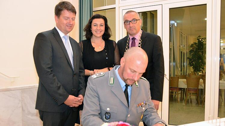 Batallionskommandeur Oberstleutnant Simon Leidner trägt sich ins Goldene Buch der Marktgemeinde Bad Bocklet ein.  Ihm schauen Landtagsabgeordneter Sandro Kirchner (CSU), Bundestagsabgeordnete Dorothee Bär (CSU) und Bürgermeister Andreas Sandwall über die Schulter.