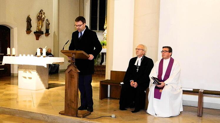 Stefan Kuhn (am Ambo), Vorsitzender des Evangelischen Arbeitskreises der CSU, mit Dekan Hans-Martin Lechner (Mitte) und Pfarrer Marcus Wolf. Foto: Nietert