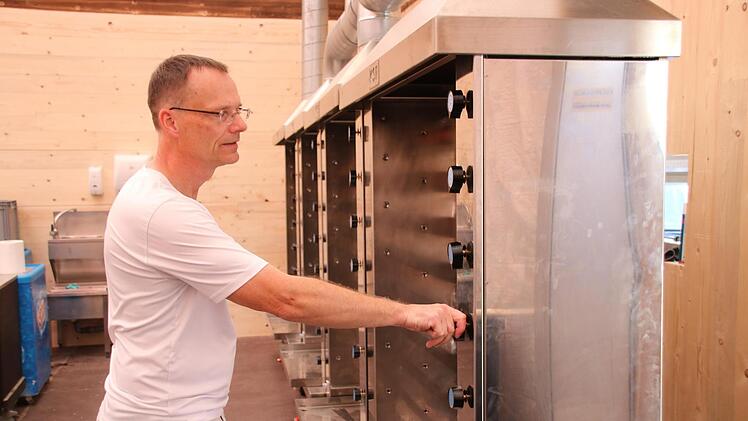 Andreas Hering hat den heißesten Arbeitsplatz. Um die 70 Grad herrschen in der Hähnchen- und Haxenbraterei. Am Freitag hat er die Anlage schon mal getestet.