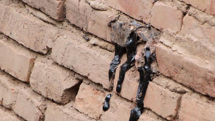 Teer läuft aus der Mauer einer alten Zisterne. Foto: Ulrike Müller