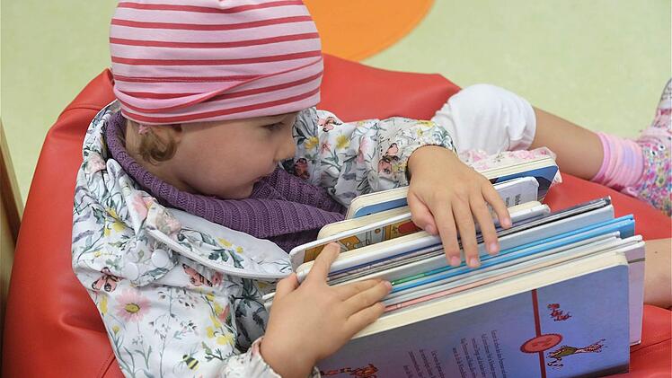 Die neue Bücherei in Thulba ist eröffnet worden. Lorena hat sich viele Bücher ausgesucht. Foto: Gerd Schaar