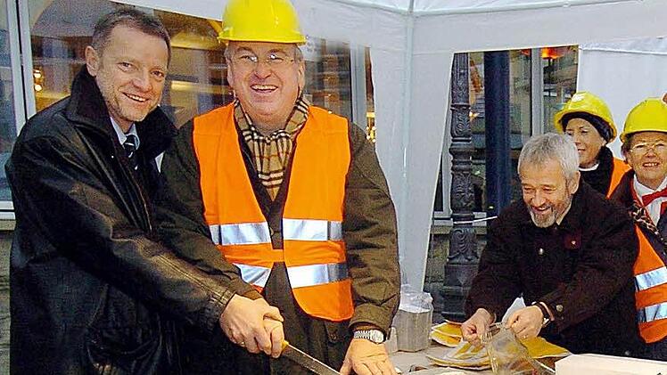 Damals waren die Rollen noch klar verteilt: Ulrich Eberhardt-Schramm (links) schneidet, Heinrich Fehling (Mitte) verteilt. Nun fordert Fehling Eberhardt-Schramm heraus. Das Foto mit Bäckermeister Rainer Reißenweber (zweiter von links) und Renate Reißenweber (rechts) entstand im November 2004 bei einer Benefizaktion fürs Sozialpädiatrische Zentrum (SPZ). Foto: CT-Archiv/Hagen Lehmann