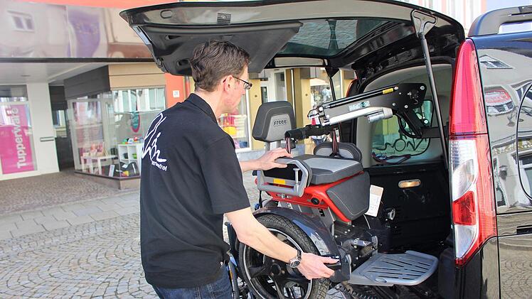 Daniel Alt auf dem Marktplatz: Mit einem eingebauten Kran hebt er den schweren Segway-Rollstuhl aus dem Auto. Foto: Julia Raab