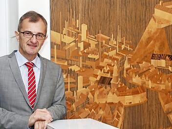 Der gebürtige Kulmbacher Harry Weiß vor einem Kunstwerk Max Wilds, das im ersten Obergeschoss der Sparkassen-Hauptstelle zu sehen ist und seine Heimatstadt zeigt. Foto: Archiv/Wolfgang Schoberth