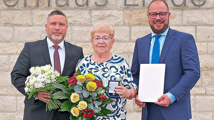 Au&szlig;ergew&ouml;hnliche Ehrung: Im Ahorner B&uuml;rgerhaus &bdquo;Linde&ldquo; haben Sebastian Straubel (rechts) und Martin Finzel das Ehrenzeichen des Bayerischen Ministerpr&auml;sidenten f&uuml;r Verdienste im Ehrenamt an Gudrun Zwilling &uuml;berreicht. Landratsamt Coburg / Berthold...