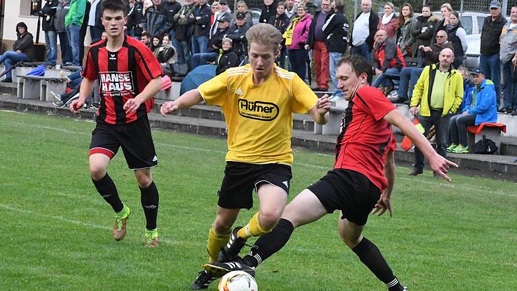 Die Fans im R&uuml;cken und den Blick nach vorne gerichtet: Der Thulbaer Sebastian Gah und dessen Probleme mit dem gestreckten Bein vom Bad Br&uuml;ckenauer Burkhard Sch&uuml;&szlig;ler (rechts). Foto: Hopf