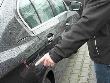 14 Autos auf dem Freigelände der BMW-Niederlassung Herrnleben wurden am Wochenende beschädigt. Verkäufer Ernst Kolb zeigt einen der vielen Kratzer, die bei hochwertigen Neufahrzeugen wahrscheinlich eine Komplettlackierung erfordern. Foto: Peter Müller