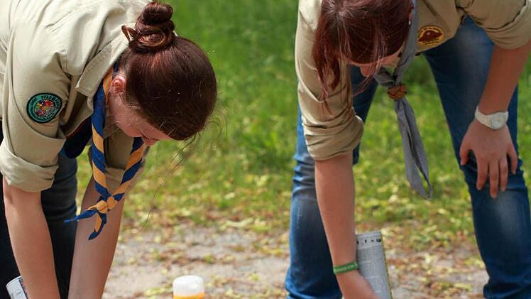 Sandra Wendel und Sandra Schwemmlein verzieren den Gartenweg des Regens-Wagner-Geländes mit bunten Pfadfinder-Lilien.