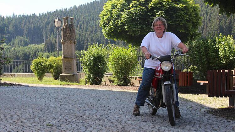Mit ihrem Moped bringt die Grabpflegerin die Pflanzen bis ganz nach oben auf den Friedhof in Wallenfels.  Fotos: Sarah Dann