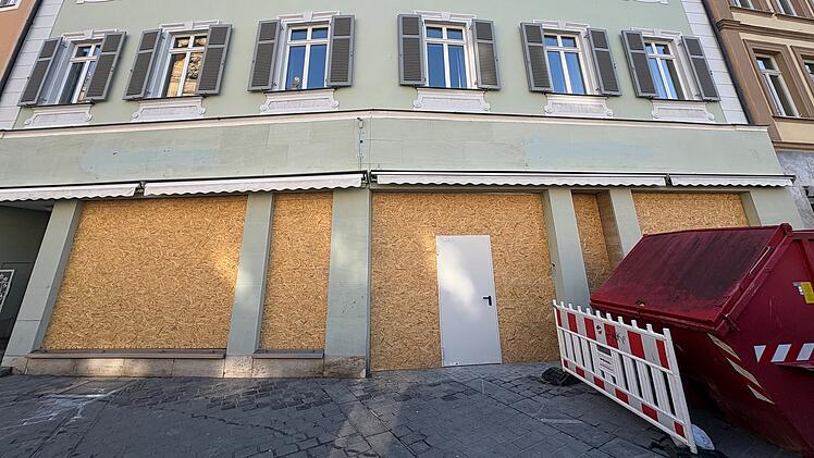 Ein Geb&auml;ude in der Bamberger Innenstadt mit Holzverkleidung an den Schaufenstern. Eine bekannte Kette wird bald eine Filiale hier er&ouml;ffnen. Ein roter Container steht vor dem Geb&auml;ude.