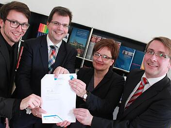 Thomas Kießlich, Bürgermeister Christian Lange, Claudia Lehnerer und Matthias Pfeufer präsentieren die unterschriebene Zielvereinbarung, die für eine neue Stabsstelle im neu eingerichteten Bildungsbüro sorgt (v.l.). Foto: Anna Lienhardt